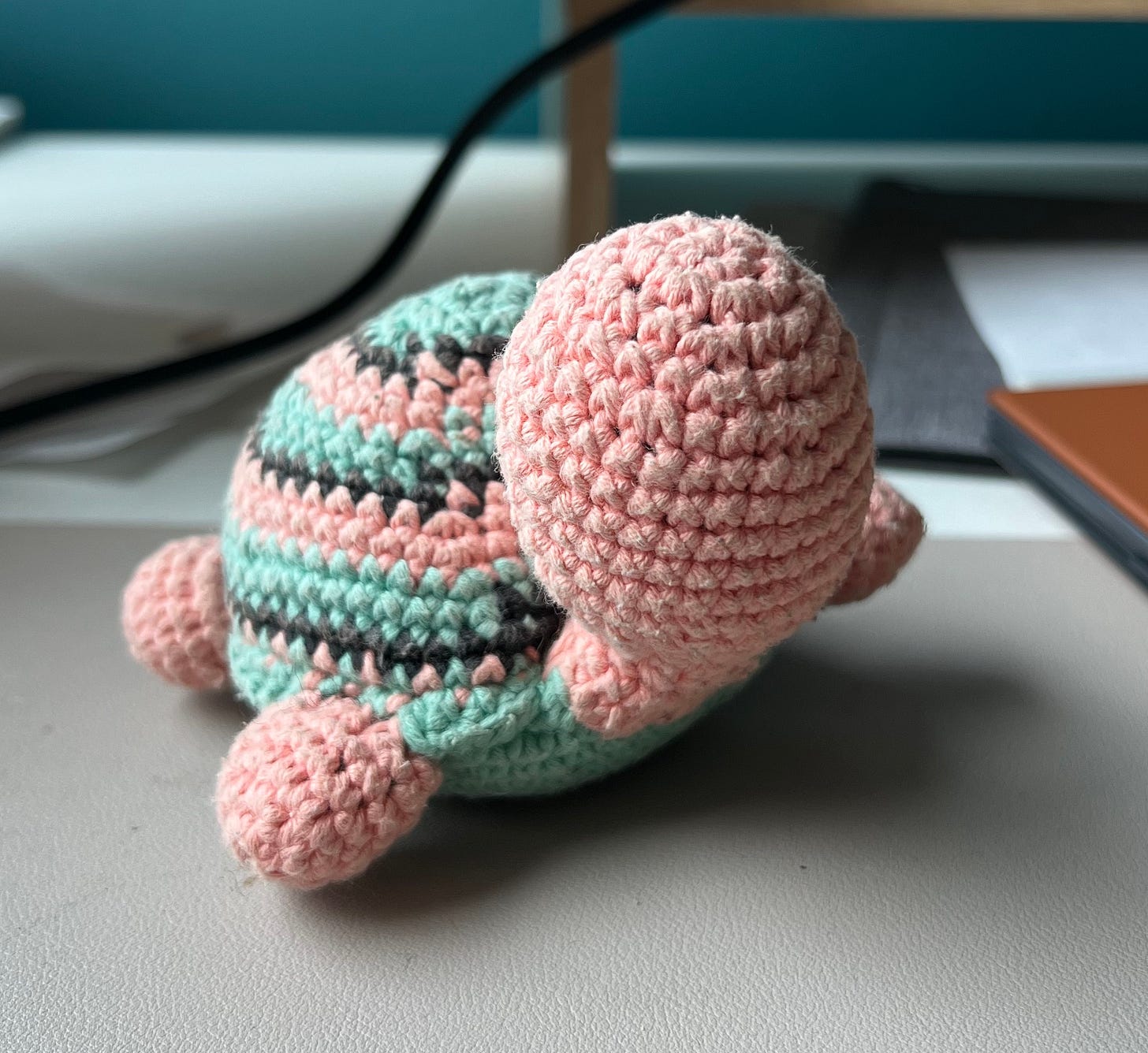 Photo of a small crocheted turtle on a desk